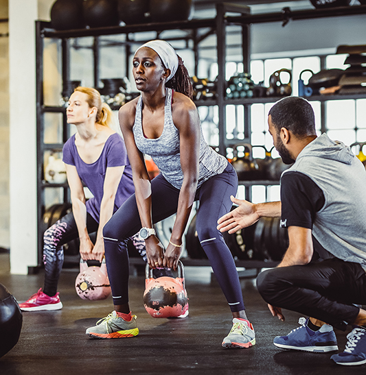Small group training with kettlebells in a gym.