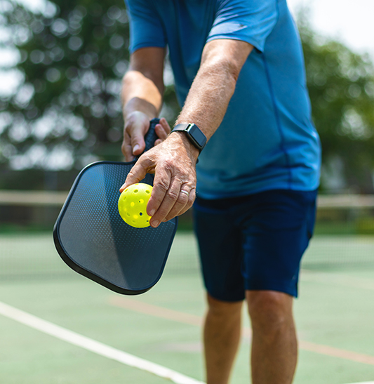 Man serving tennis ball.