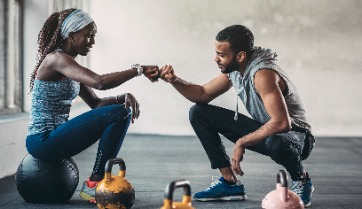 2 people with fist bump in corporate fitness center